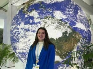 Annika Barron standing in front of giant globe display